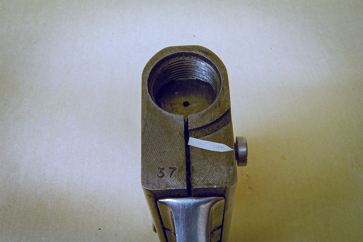 Takedown slot cut in front of Navy Arms Greener. Arrow shows the clamping screw that prevents the barrel from turning.